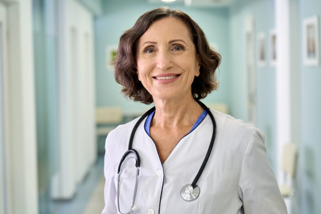 Smiling female happy doctor pediatrician standing in clinic hospital. Portrait.